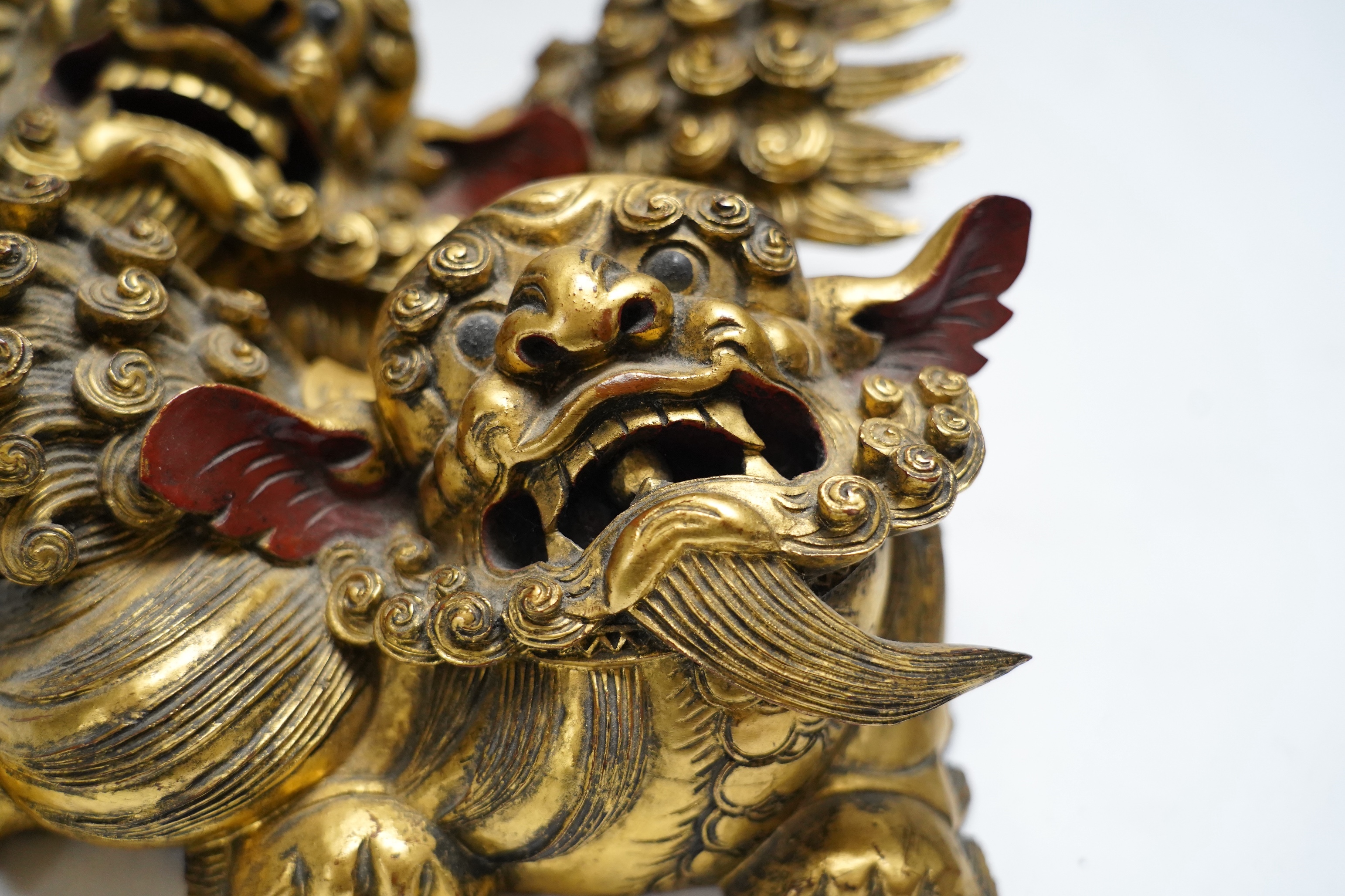 A pair of 20th century Chinese carved giltwood lion mounts, 23cm wide